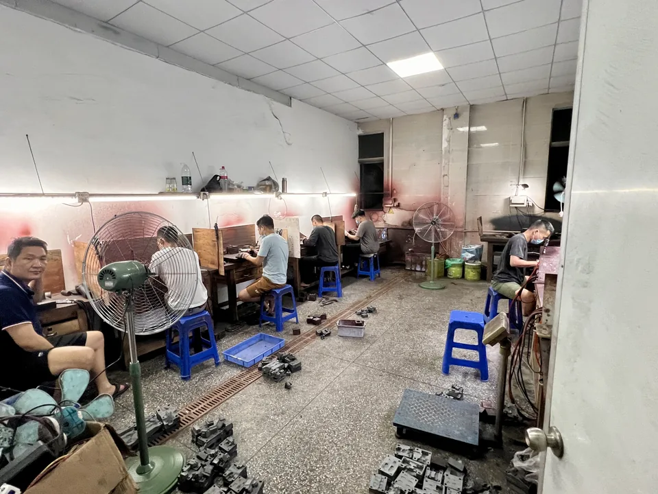 Toolmakers polishing mold parts in the Dashan Precision factory